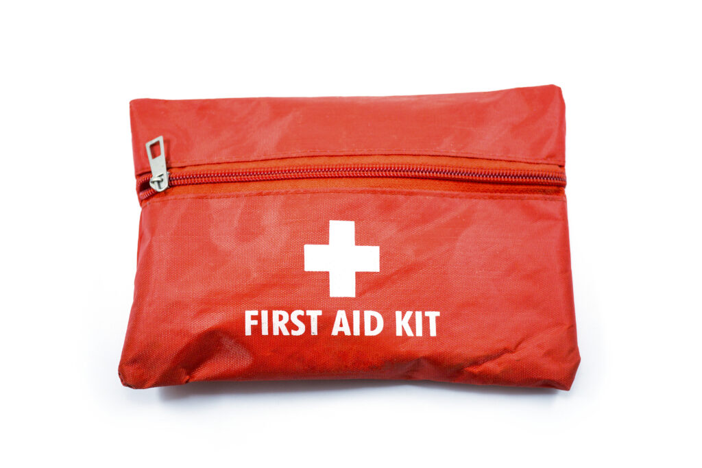 Portable red first aid kit bag with a zip usually placed in the car, in closeup