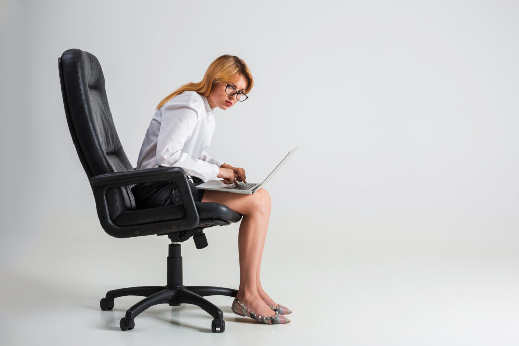 young woman sitting on the chair and using laptop